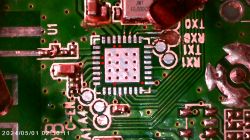 Close-up of a circuit board with a highlighted integrated circuit and solder connections.
