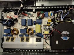 Widok wnętrza urządzenia elektronicznego z wieloma komponentami na płytce drukowanej.