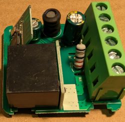 Close-up of a circuit board with relay, capacitors, resistor, and screw terminals
