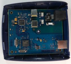 Płytka drukowana z elementami elektronicznymi w niebieskiej obudowie.