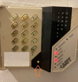 Panel alarmowy DSC PC 3000 z podświetloną trójkątną diodą w dolnym rogu
