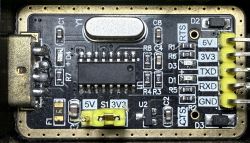 USB to UART converter board with visible pins and electronic components.