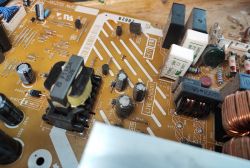 Wnętrze płyty głównej starego telewizora plazmowego z komponentami elektronicznymi.