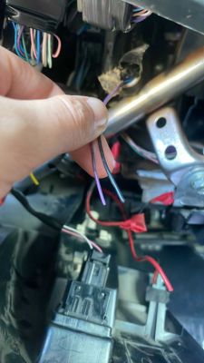 Zbliżenie na rękę trzymającą fioletowe przewody w kabinie Toyota Prius 4 2016
