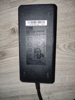 Zasilacz AcBel z oznaczeniem modelu ADCO18, z wejściem 220-240V i wyjściem 12V6A, leżący na podłodze.