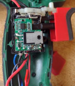 Zbliżenie na wnętrze wiertarki z widokiem na obwody elektroniczne i przewody.