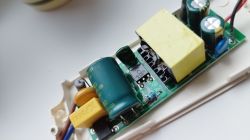 Zbliżenie na wnętrze zasilacza z komponentami elektronicznymi.