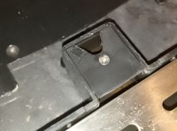 Zbliżenie na plastikowy element z zamocowaną śrubą i cienką uszczelką gumową