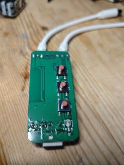 Circuit board with three buttons on a wooden table