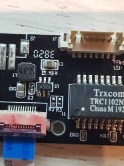 Zbliżenie na płytkę drukowaną z różnymi elementami elektronicznymi i złączami.