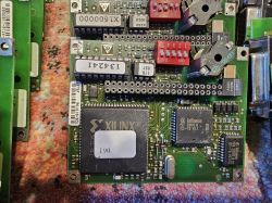 Stara płytka elektroniczna z komponentami Xilinx i Infineon na kolorowym tle