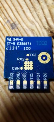 Electronic module with pins and labels on a wooden surface