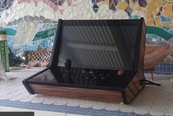 Maszyna arcade z joystickiem i przyciskami, obudowa w stylu retro imitująca drewno.