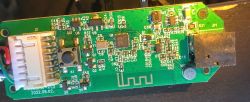 Circuit board with electronic components, including a connector, microphone, and an integrated circuit.