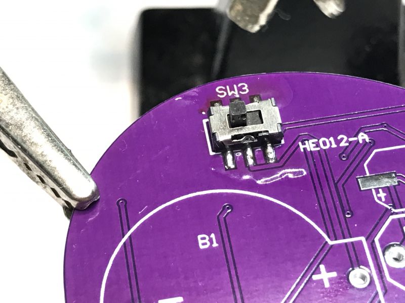 SMD Switch on PCB Close-up of an SMD switch mounted on a purple PCB marked SW3.