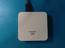 White electronic module RTL8720CF WBR3 with connected USB-C cable on a blue background.