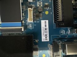 Nahaufnahme einer blauen Leiterplatte mit Steckverbindern, SMD-Bauteilen und Barcode-Etikett