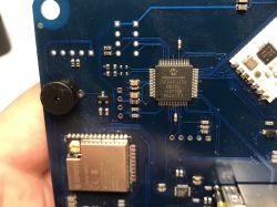 Close-up of a PCB showing a Microchip PIC24FJ256 chip and an ESP32 module.