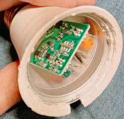 Inside View of an LED Bulb with Circuit Board Close-up of the interior of an LED bulb, showing a green circuit board with electronic components.