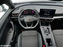 Car interior with Cupra steering wheel, digital instrument cluster, and infotainment screen on the dashboard
