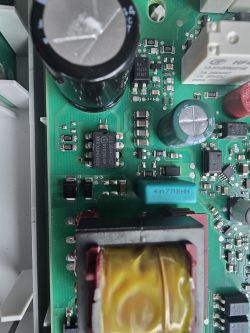 Zbliżenie na płytę PCB z różnymi podzespołami, w tym kondensatory i chipy.