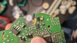 Płytka PCB z uszkodzonym komponentem elektronicznym przy krawędzi.