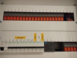Wewnątrz skrzynki elektrycznej z przekaźnikami i zasilaczem.