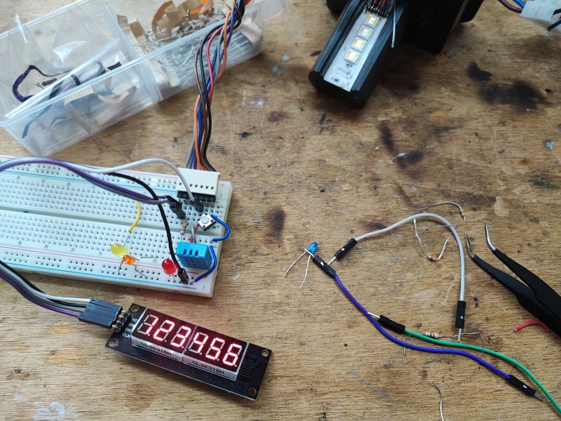 Breadboard Prototype with LED Display Prototype with a breadboard, LEDs, and a display on a wooden table.