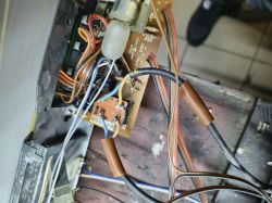 Zbliżenie na wnętrze obudowy urządzenia elektronicznego, ukazujące różne przewody i elementy elektroniczne.