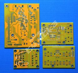 Cztery żółte płytki PCB leżące na niebieskim tle, z widocznymi ścieżkami i otworami montażowymi