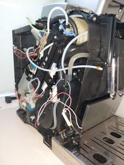 Widok wnętrza ekspresu do kawy DeLonghi ECAM370.95.S z widocznymi elementami elektronicznymi.