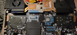 Wnętrze gamingowego laptopa z wymienionymi termopadami oznaczonymi niebieskimi znakami.