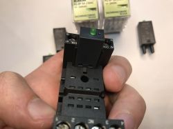 Zbliżenie na przekaźnik elektromagnetyczny osadzony w podstawce z oznaczeniami styków