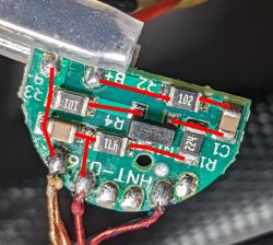 Mała płytka elektroniczna z czterema rezystorami i dwoma kondensatorami.