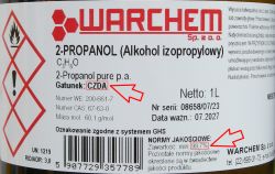 Etykieta na butelce 2-propanolu z oznaczeniem czystości CZDA i zawartości 99,7%.
