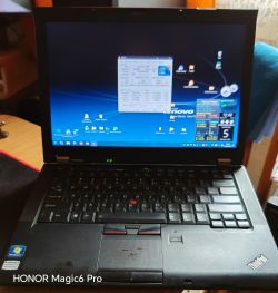 Stary laptop Lenovo T410 z uruchomionym systemem Windows na ekranie.