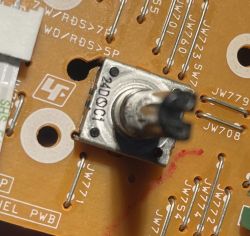Zbliżenie enkodera obrotowego na płytce PCB z oznaczeniem „24D0C1” i metalowym wałkiem