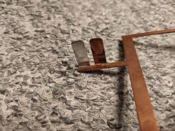 Miedziane elementy ze skrzynki bezpieczników, z korozją na jednym ze styków.