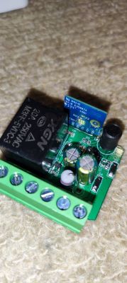 Close-up of an electronic module with a relay and capacitors.