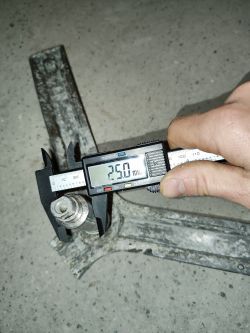 Pomiary krzyżaka bębna pralki za pomocą suwmiarki cyfrowej pokazującej 25,0 mm.