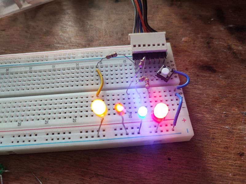 Breadboard with LEDs and Button View of a breadboard with connected LEDs of various colors and a button.