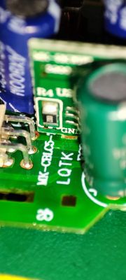 Circuit Board with Capacitors and Markings Close-up of a circuit board with electronic components.