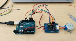 Arduino Uno połączone przewodami z modułem ULN2003 i silnikiem krokowym 28BYJ-48 na biurku