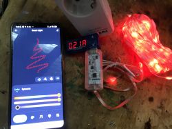 Smartphone with an app controlling LED lights, display showing power consumption of 0.21A.