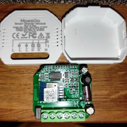 Image of an open MoesGo MS-105B dimmer module with visible internal electronics on a wooden surface.