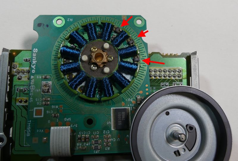 Zdjęcie przedstawia wewnętrzne elementy elektroniczne urządzenia typu silnik z cewką i płytką PCB.