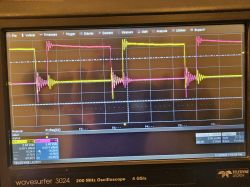 Oscilloscope display with square wave signals in yellow and pink.
