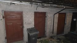 Widok na trzy drewniane drzwi w murowanej ścianie z cegły.