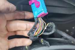 Przewody i wtyczka elektryczna w samochodzie z oznakami naprawy.