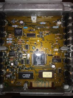 Wnętrze sterownika ECU: płytka PCB z układami scalonymi, kondensatorami i złączami w metalowej obudowie